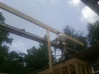 Carpenter setting a ridge beam over a new addition frame — Ice Dam Removal by Roofing Brothers in Greenwood Springs