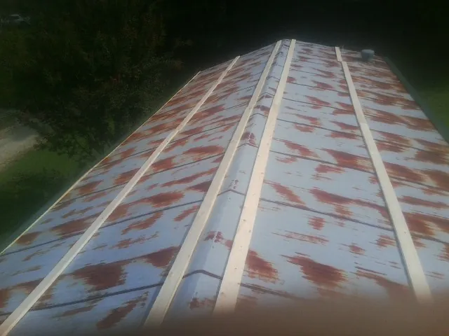 Rusted metal roof panels with new wood purlins before replacement — Storm Damage Roof Repair in Greenwood Springs by Roofing Brothers