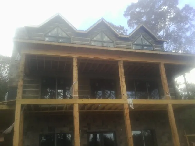 Dormers and porch framing on a large log home under construction — Roof Coating work by our crew in Greenwood Springs
