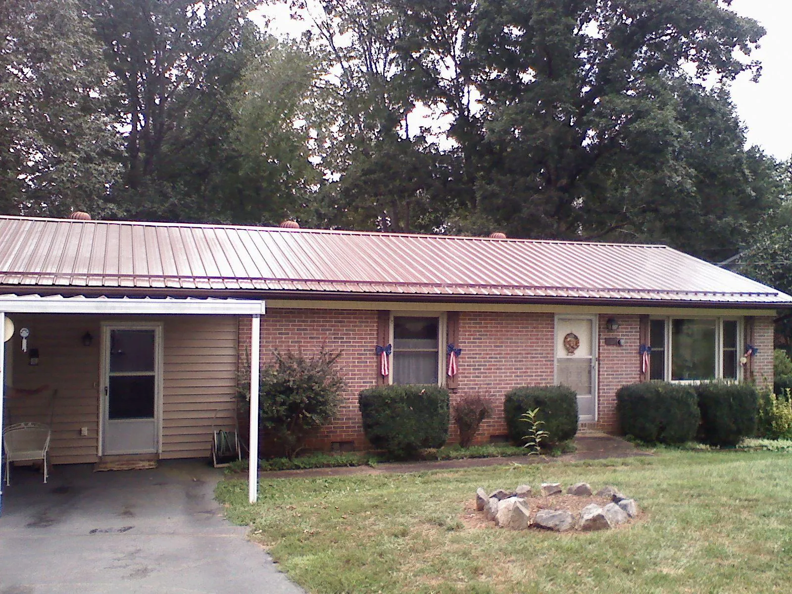 Bronze metal roof and carport on a brick ranch home — Roof Repair work by our crew in Greenwood Springs